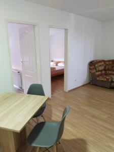 una habitación con una mesa y sillas y una cama en Altea 1, en Vršac