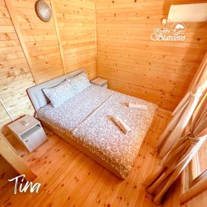 a small bedroom with a bed in a wooden room at Apartmani Konoba Starčevo in Virpazar