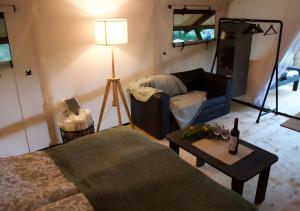 a living room with a couch and a table at Glempings Eglenieki in Almale