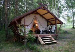 a tent in the middle of a forest at Glempings Eglenieki in Almale