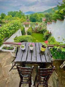 a wooden table with two chairs and flowers on it at Villa MAKA - Balchik, Albena Village Zone in Balchik