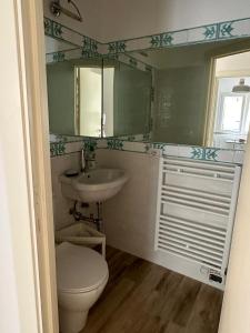 un bagno con un water, un lavandino e uno specchio di Albicocca a Falconara Marittima Altre 16 foto