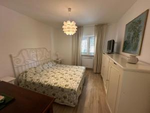 una camera da letto con un letto, una televisione e un lampadario di Albicocca a Falconara Marittima