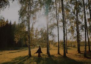 una mujer caminando por un campo con árboles en Glempings Dīķīši, en Stākas 6 fotos más