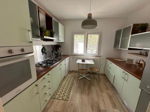 a kitchen with white cabinets and a table in it at Albicocca in Falconara Marittima