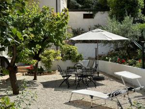 un patio con tavolo, sedie e ombrellone di Albicocca a Falconara Marittima