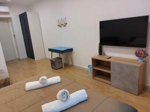 a living room with a flat screen tv and two towels at B&B Terrazza In Centro in Castellammare di Stabia