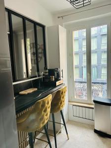 a kitchen with a counter and a yellow chair at Résidence Renan - Paris Porte de Versailles in Issy-les-Moulineaux