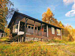 ein Holzhaus mit Veranda auf einem Feld in der Unterkunft Boka Borgafjäll in Borgafjäll