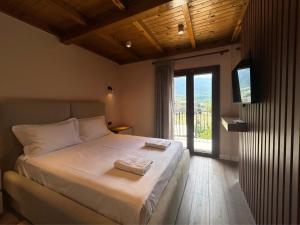 a bedroom with a large bed and a large window at Hotel Vila Ami in Tragjas