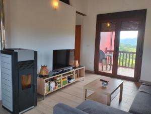 a living room with a tv and a couch and a table at La Casa de Nuria in Cangas de Onís