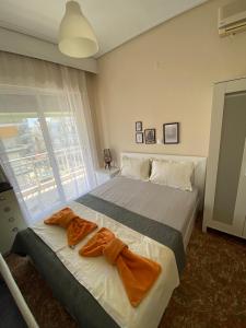 ein Schlafzimmer mit einem großen Bett mit zwei Handtüchern darauf in der Unterkunft New Zeusplace apartment with private parking Paralia Katerini in Paralia Katerinis