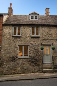 a stone house with two windows and a door at Cosy Country Townhouse in Woodstock in Woodstock