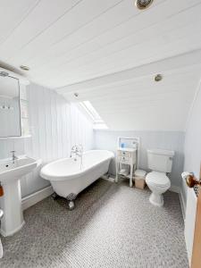 a bathroom with a tub and a toilet and a sink at St Vincent Guest House in Lynton +143 photos