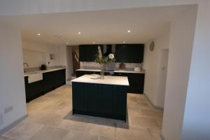 a kitchen with green cabinets and a counter with flowers on it at Cosy Country Townhouse in Woodstock in Woodstock +26 photos