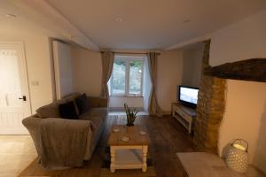a living room with a couch and a television at Cosy Country Townhouse in Woodstock in Woodstock