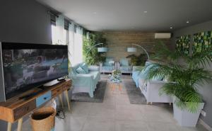 ein Wohnzimmer mit Sofas und einem Flachbildfernseher in der Unterkunft Villa prestigieuse « Bellezza » By HC in Carqueiranne