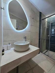 a bathroom with a sink and a mirror at Faros Rooms in Loutro