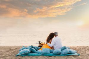 a couple sitting on the beach watching the sunset at Villa Fiesta - Beachfront Getaway in Verna