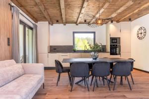 Una cocina y un comedor con mesa y sillas. en Luxury House Masuria, en Jabłonka