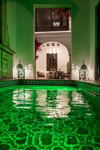 a swimming pool in a house with green walls at Gandesa, Palace House in Seville