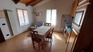 a kitchen with a table and chairs in a room at Il Nido Del Viaggiatore in Vallebona