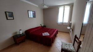 a bedroom with a red bed and a window at Il Nido Del Viaggiatore in Vallebona