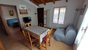 a room with a table and a couch and a table and chairs at Il Nido Del Viaggiatore in Vallebona