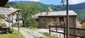 a small stone house in a village with a fence at Rifugio Ca' da Cardella in Mendatica
