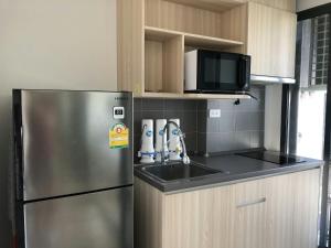 a kitchen with a stainless steel refrigerator and a sink at Ideo O2 BTS Bangna in Bangkok