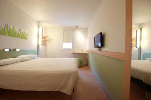 サン・ポール・レ・ダックスにあるibis budget Saint Paul Les Daxのベッド2台とテレビが備わるホテルルームです。