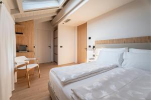 a bedroom with a bed and a desk and a chair at Hotel Al Maso in Riva del Garda