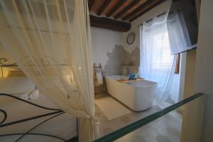 a bathroom with a white tub and a window at Sogno Amiatino in Abbadia San Salvatore