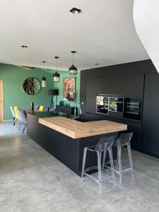 a kitchen with a wooden counter and chairs in it at Villa avec piscine chauffée in Ancy