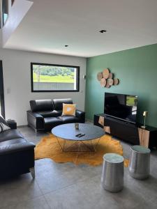 a living room with a couch and a table at Villa avec piscine chauffée in Ancy