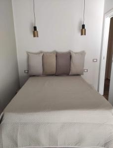 a bedroom with a large bed with white sheets and pillows at Casa Vacanze Scyauru in Santa Elisabetta