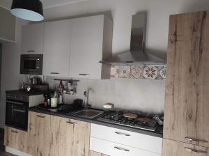 a kitchen with white cabinets and a stove top oven at Casa Vacanze Scyauru in Santa Elisabetta