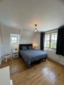 a bedroom with a bed and two windows at Oasis de Sérénité avec piscine in La Baule +18 photos