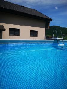 a swimming pool in front of a house at Apartman Enjoy in Bihać