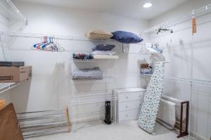 a white closet with white shelves and a tie at Lighthouse Seclusion in Ocean Pines +79 photos