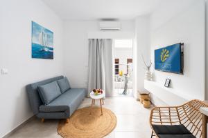 a living room with a blue chair and a table at Faflagos Apartments in Psari Forada