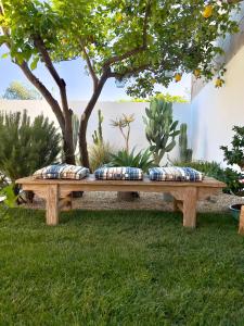 a wooden bench in the grass with pillows on it at Sustai in Càbras