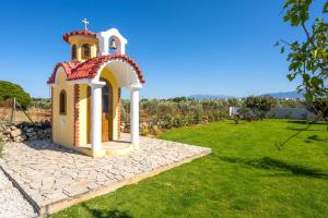 a small chapel in a field of green grass at Luxury Oasis in Chania - Private Pool, BBQ & Garden by WeHome in Chania Town