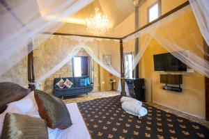 a bedroom with a bed and a tv and a couch at Beitkamle in Batroûn