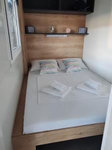 a bed in a small room with two pillows at EMMI Mobile Home in Sveti Petar