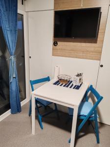 a white table with two blue chairs and a tv at EMMI Mobile Home in Sveti Petar