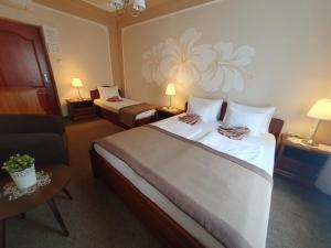 a hotel room with a large bed and a couch at Duna Panzió in Győr