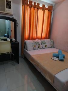 a bedroom with a bed with an orange curtain at Grass residence tower2 29th in Manila +26 photos