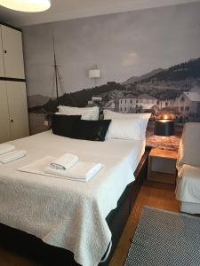 a bedroom with a large bed with towels on it at Old port in Baška Voda