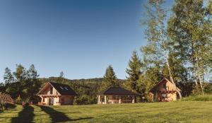 two wooden cabins in a field with trees at Domki na Stecówce in Istebna